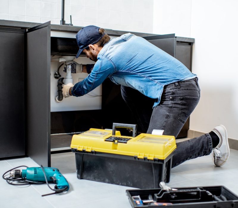 Professional plumber repairing a sink in Kuala Lumpur.